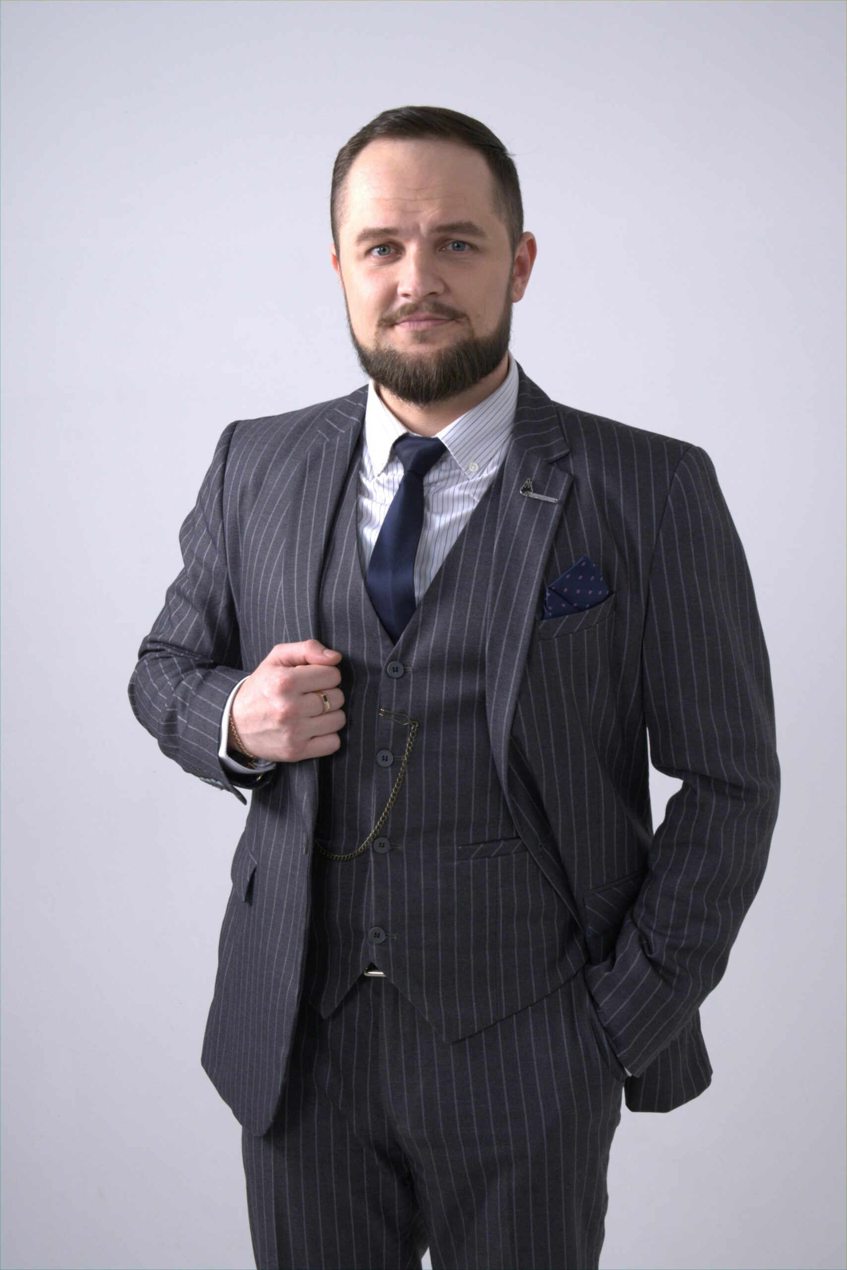 Portrait of a confident businessman in an elegant pinstripe suit with a white background.
