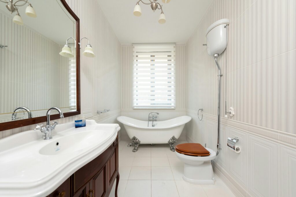 Spacious bathroom featuring a classic clawfoot tub, vanity, and wooden toilet seat.