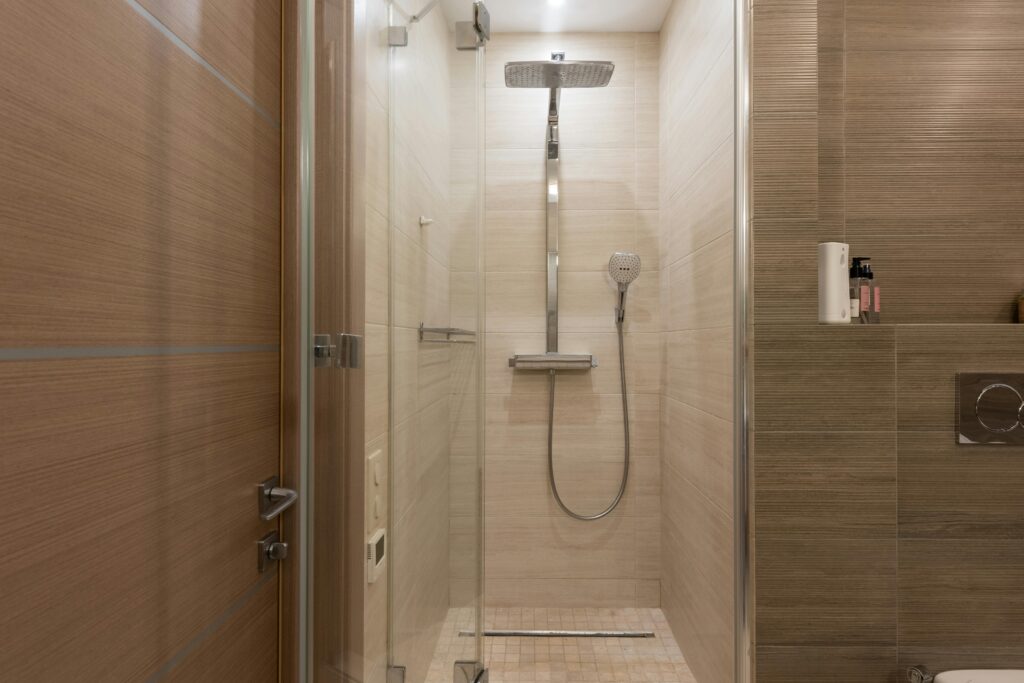 Sleek modern shower with glass door in a contemporary bathroom setting, featuring elegant interior design.
