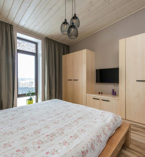 Inviting bedroom showcasing modern interior design with warm wooden elements and natural light.