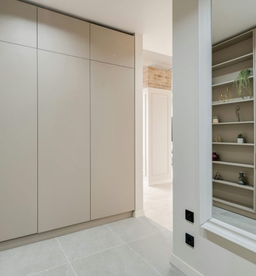 Explore this sleek and modern corridor featuring minimalist design with built-in wardrobes and stylish shelves.