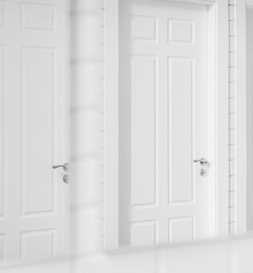 Clean and simple white doors with handles, reflecting in a mirror for a minimalist aesthetic.